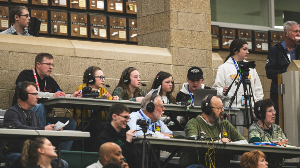 students collaborating and broadcasting a sports game at a high school in the media row